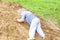 A little boy climbs a mountain with sand.