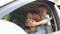 A little boy closes his mother`s eyes while driving a car. Child indulges in car