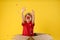 Little boy with clown nose in cardboard box under confetti shower on background. April fool`s day