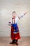 Little boy in colorful costume doing folk dancing