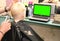 A little boy is cutting a hairdresser in the salon. The kid is watching a cartoon. Green screen on a laptop for signature