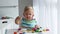 A little boy disassembles and assembles a wooden pyramid. Educational logical toys for children.