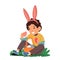 Little Boy Donning Rabbit Ears Picks Brightly Colored Easter Eggs From The Grass. The Joyous And Festive Image