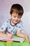 Little boy drawing with color pencils. Boy, drawing a picture for fathers day. Small boy draws at the table