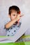 Little boy drawing with color pencils. Boy, drawing a picture for fathers day. Small boy draws at the table