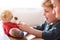 Little boy dressing teddy bear