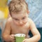 Little boy is drinking a cocoa with a mischievous expression.