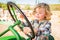 Little Boy Driving A Tractor in a Rustic Ranch Setting at the Pumpkin Patch