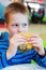 Little boy eating burger