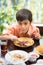 Little boy eating for food meal in the restuarant