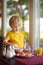 Little boy eating healthy breakfast in hotel restaurant. Tasty meal in home