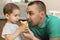 Little boy eating ice cream in the company of his father