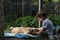 Little boy embracing his dog on the garden. Child and little dog are lying together on the grass.