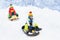 Little boy enjoying a sleigh ride. Child sledding. Toddler kid riding a sledge. Children play outdoors in snow. Kids sled in the