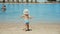 Little boy enjoying warm water at seaside. Cute child running at sand beach.