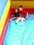 Little boy escorts a little girl down a large slide.