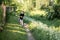 Little boy and favorite companion dog coker spaniel friend walking in garden, trees, flowers, street. Light day outdoor