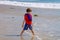 Little Boy With Feet Sunken Into the Beach Sand Stands With Legs