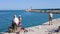 A little boy is fishing with his father and grandfather on the dock of the port of Pesaro