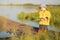 A little boy fishing and wants to catch the biggest fish. Boy on wooden dock with a fishing net