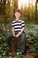 Little boy in forest on flowers field