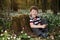 Little boy in forest on flowers field