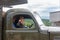 A little boy in the form of a Soviet soldier in the cockpit of an army car participates in a parade in honor of victory day