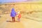 Little boy and girl with backpacks travel on the road to mountains