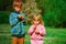 Little boy and girl blow dandelions, play in spring nature