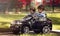 Little boy and girl driving toy car in a park