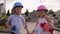 A little boy and girl in helmets and with skateboard hold hands in the Park.