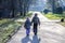 Little boy and girl holding hands and walking a long straight path