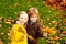 Little boy and girl hugging in autumn park. Colorful foliage, maple leaves.