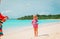 Little boy and girl play beach tennis on vacation