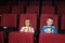 Little boy and girl with round glasses eating popcorn