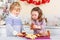 Little boy and girl, siblings, baking gingerbread cookies in domestic kitchen