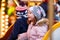 Little boy and girl, siblings on carousel at Christmas market