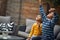 Little boy and girl sitting together outdoor and play with balloon