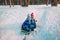 Little boy and girl slide in winter snow