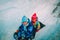 Little boy and girl slide in winter snow