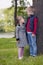 Little boy and girl on a sunny day standing on green grass near