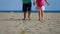 Little boy and girl walking on the beach to the camera while holding hands