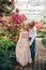 Little boy and girl are walking in a blooming garden