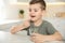 Little boy with glass of water taking vitamin capsule