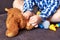 A little boy glues a plaster on a teddy bear, playing doctor