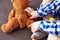 A little boy glues a plaster on a teddy bear, playing doctor