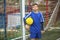 Little boy in goalkeeper uniform on football field. Sport.