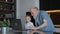 Little boy and grandfather wave greeting gesture with their hands, smile and talk to family through laptop screen