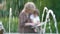 Little boy and grandmother read book in the park
