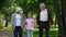 Little boy and grandparents walking in park, weekend visit, happy time together